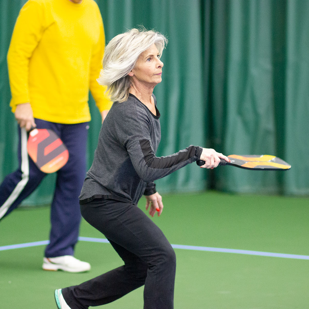 Middle aged woman playing pickleball at Parkside Fitness