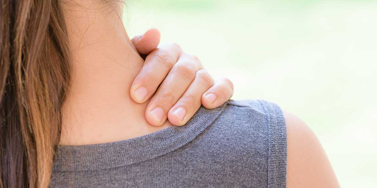 Woman using her hand to massage her neck and shoulder