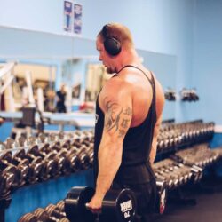 A man using Parkside Fitness dumbbells to strengthen his shoulders