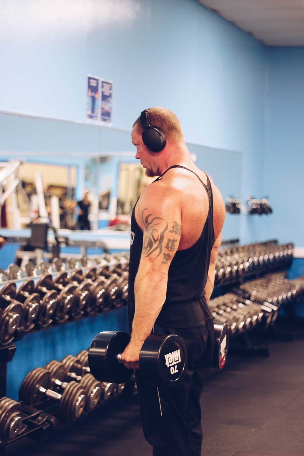 A man using Parkside Fitness dumbbells to strengthen his shoulders