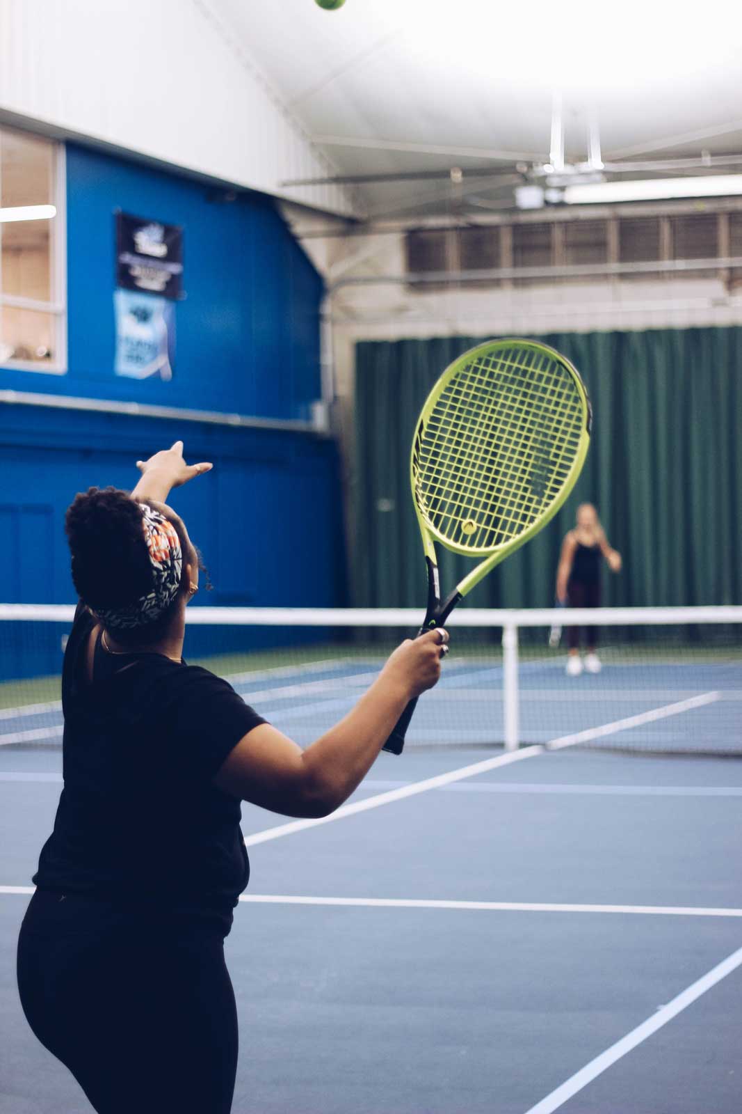 Woman serving at the Parkside Fitness tennis courts