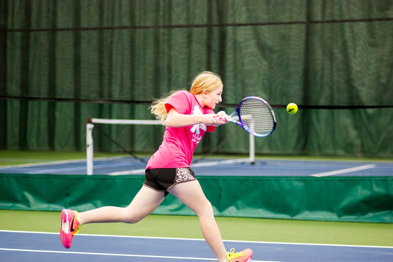 Girl returning a serve on the Pekin Park District tennis courts